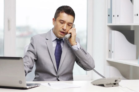 person in a white office taking a phone call