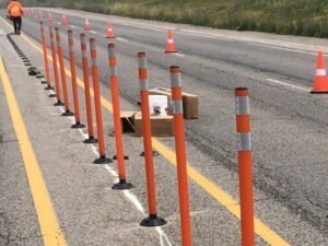 Long orange bollard installation down roadway centerline