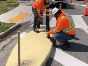 Concrete traffic calming curbs being places with bollard installation